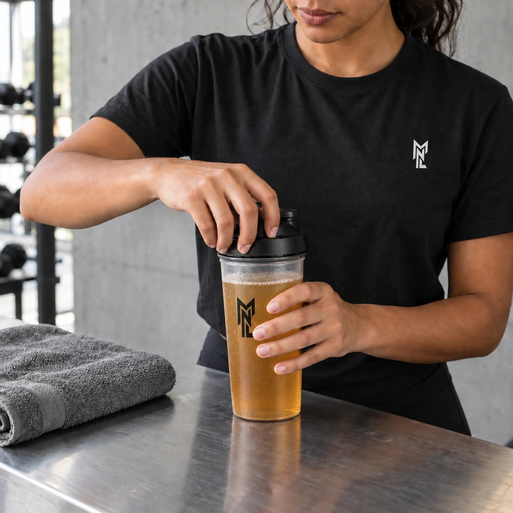 Une sportive en t-shirt noir prépare son shaker MyNutriLab.